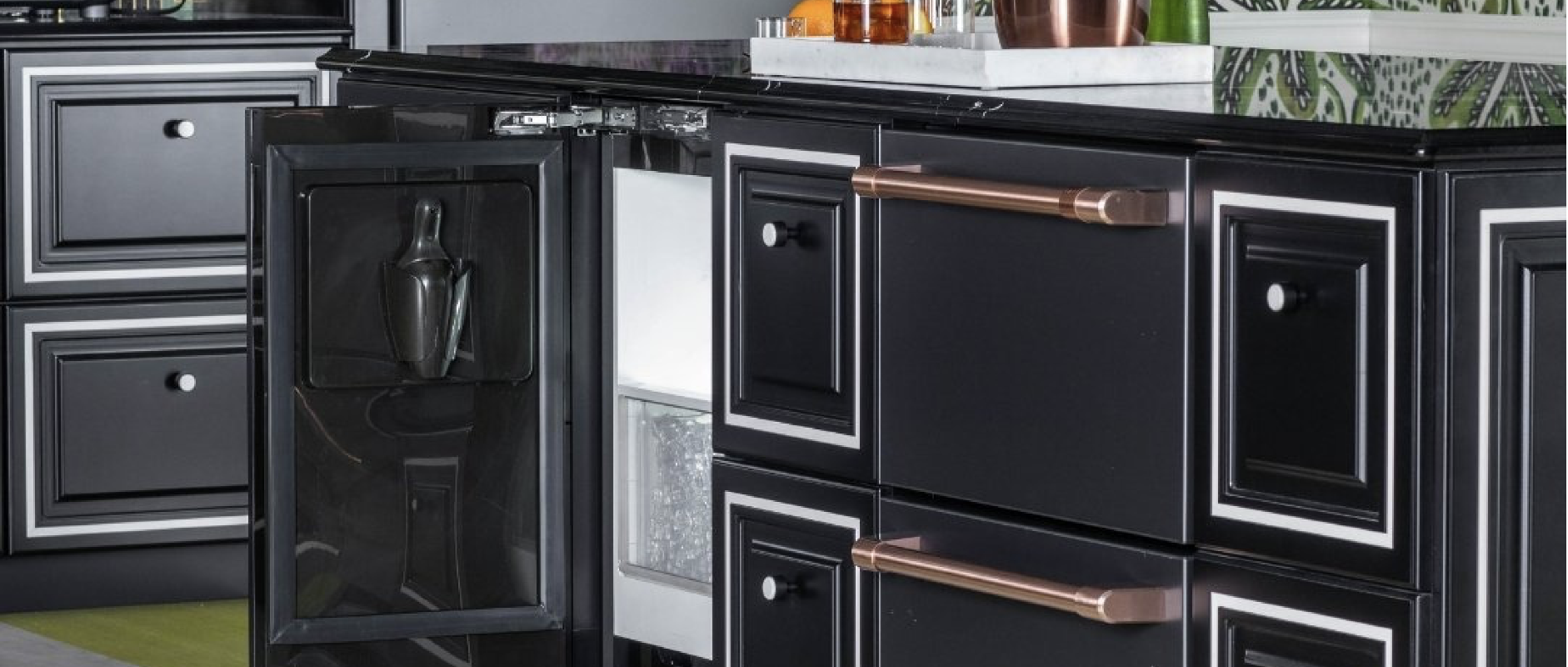 kitchen with black cabinets outlined in white featuring an undercounter ice maker with the door opened